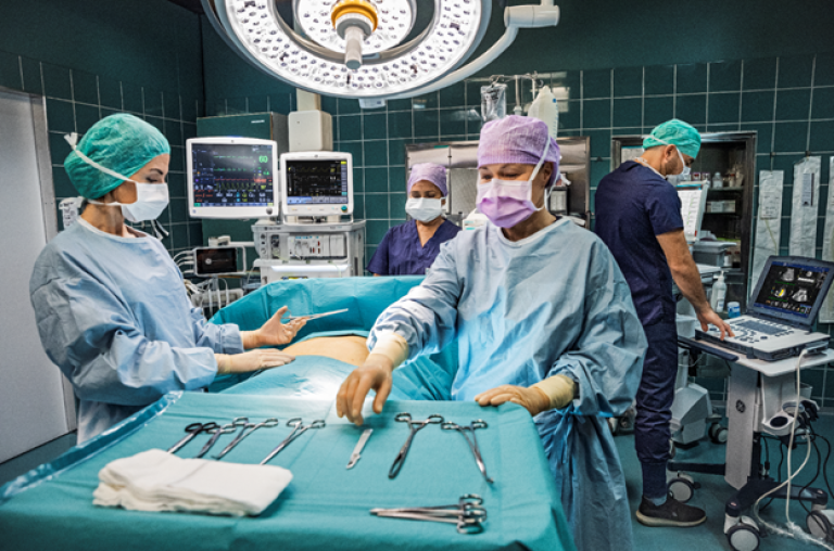 Four Clinicians in an OR performing surgery on a patient