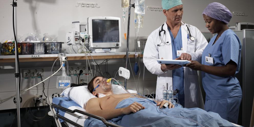 Clinicians checking on a patient in the PACU