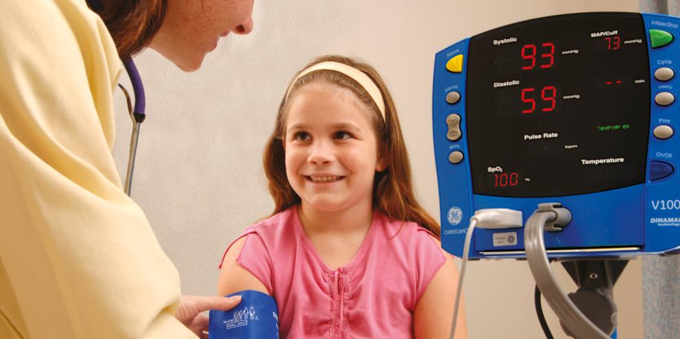 Doctor using the V100 monitor on a pediatric patient
