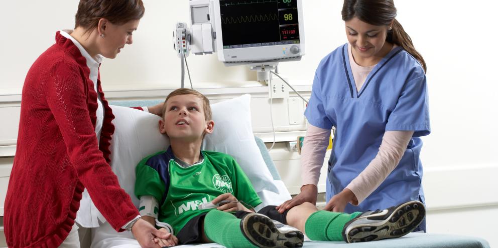 Doctor examines the leg of the football junior
