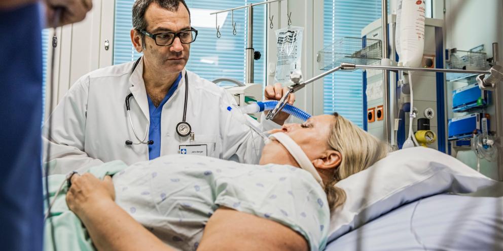 Clinician checking on an intubated patient in the ICU