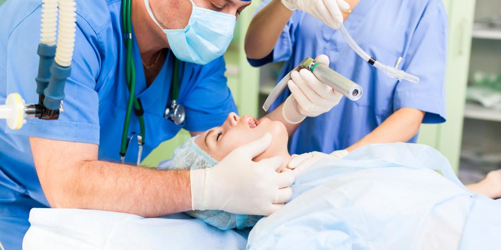 Anesthesiologist intubating patient