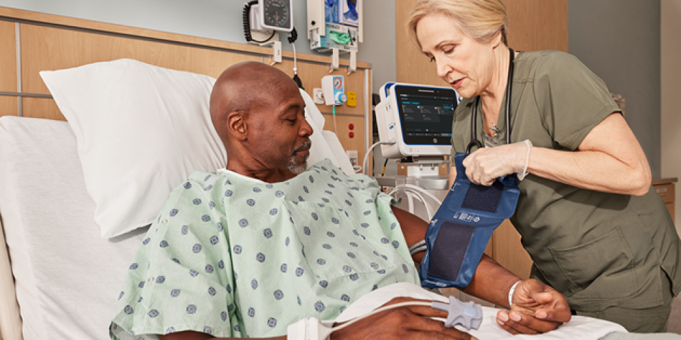 Clinician measuring BP to a patient in the ward