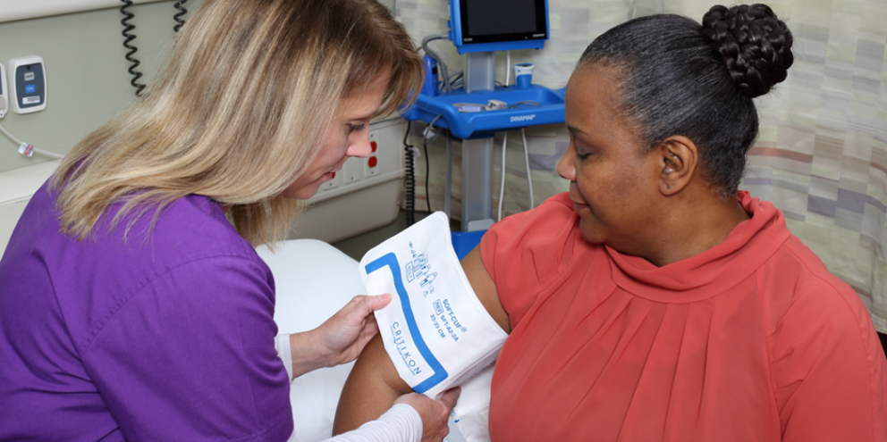 Clinician using a NIBP cuff on a patient