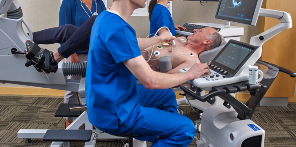 Clinicians performing an ultrasound and an ECG to a male patient