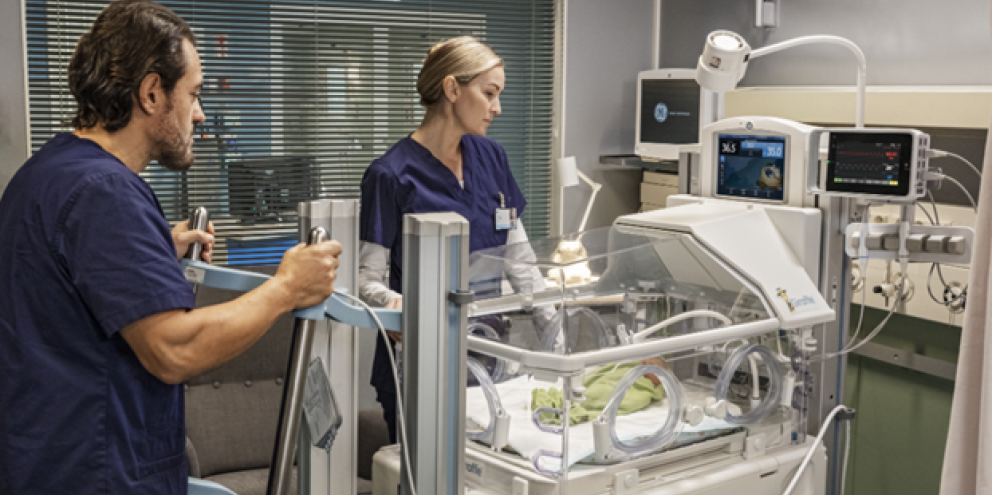 Clinicians taking care of a neonatal patient in a incubator