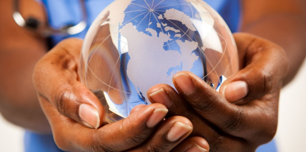 Earth globe between a clinicians hands