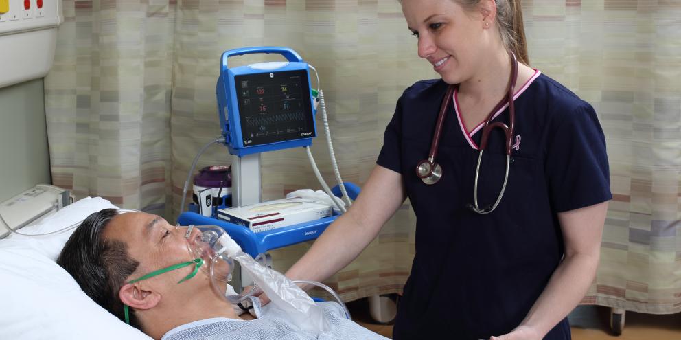 Female clinician taking care of a patient with respiratory support