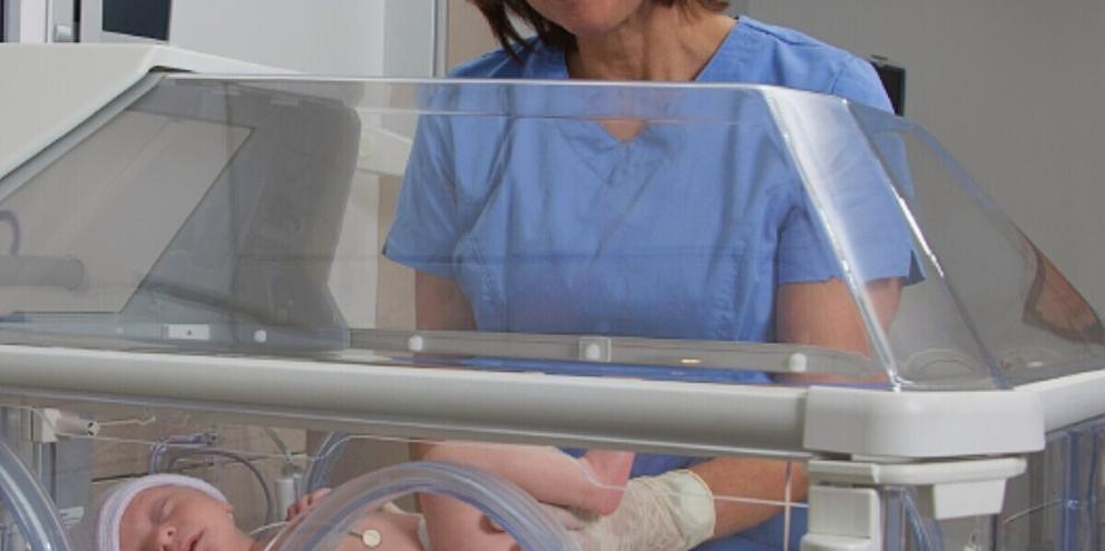 Baby in incubator with temperature probe