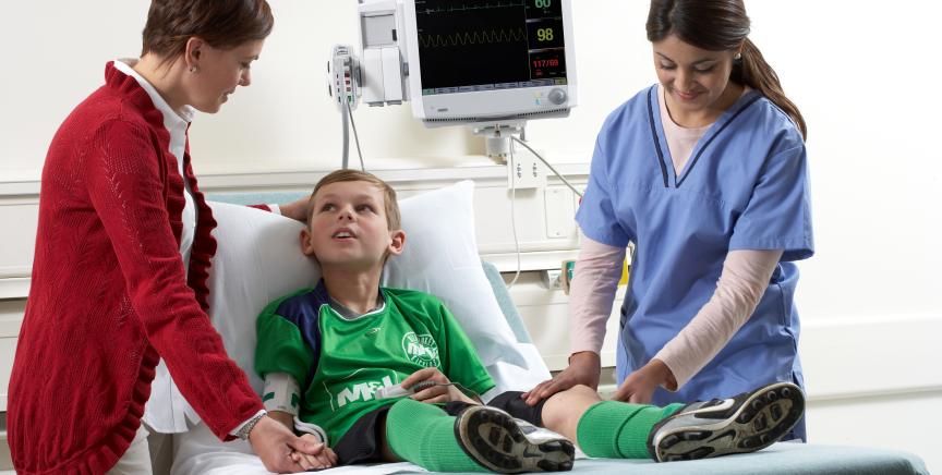 Doctor examines the leg of the football junior