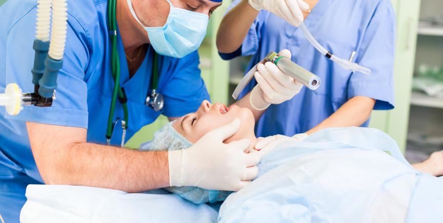 Anesthesiologist intubating patient