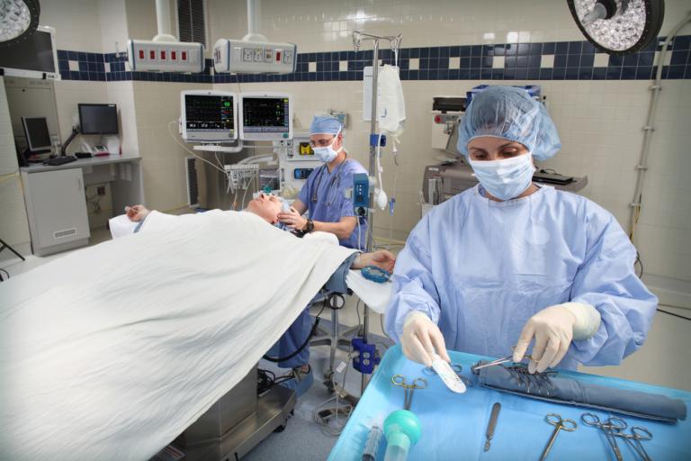 2 clinicians in the OR operating a patient
