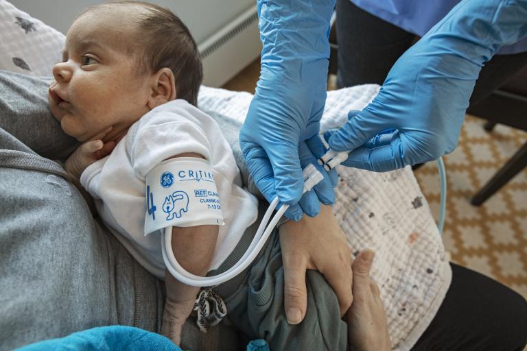 Nurse placing a cuff on a Neonatal patient