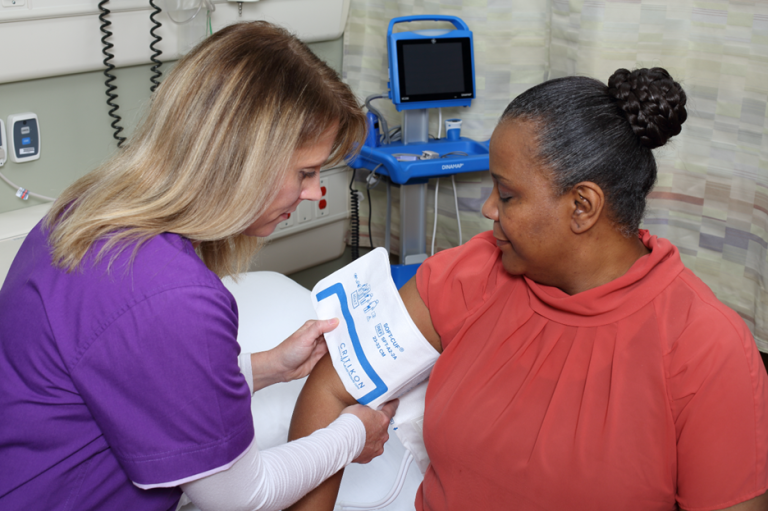 Clinician using a NIBP cuff on a patient