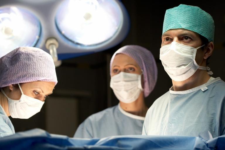 Clinicians looking at a monitor in the operating room