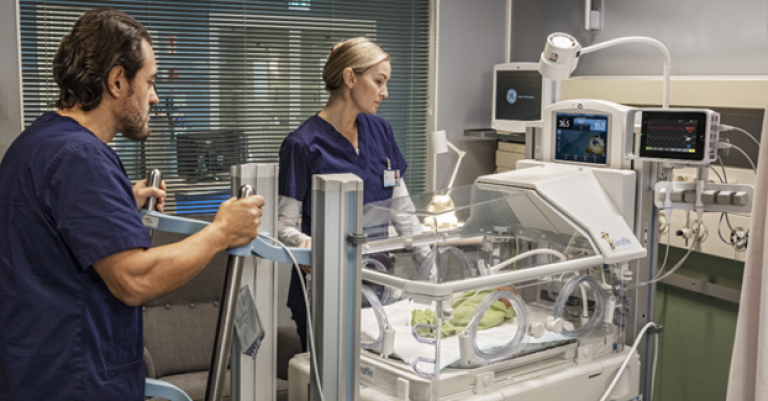 Clinicians taking care of a neonatal patient in a incubator