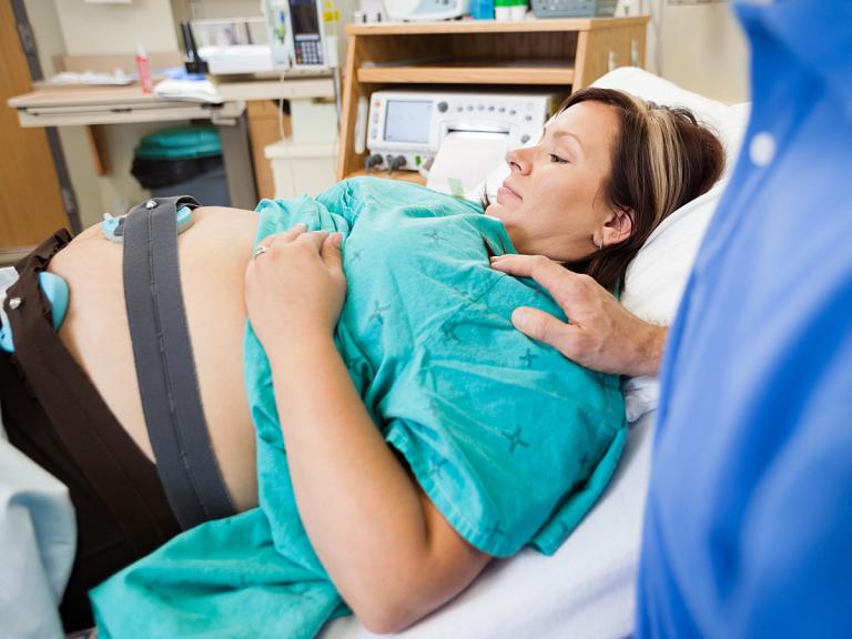 Pregnant women looking at her belly