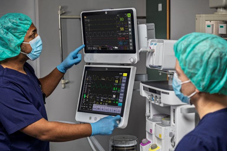 Two clinicians looking at monitor screens in the OR