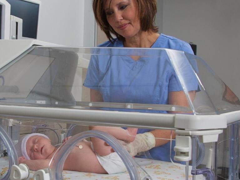 Baby in incubator with temperature probe