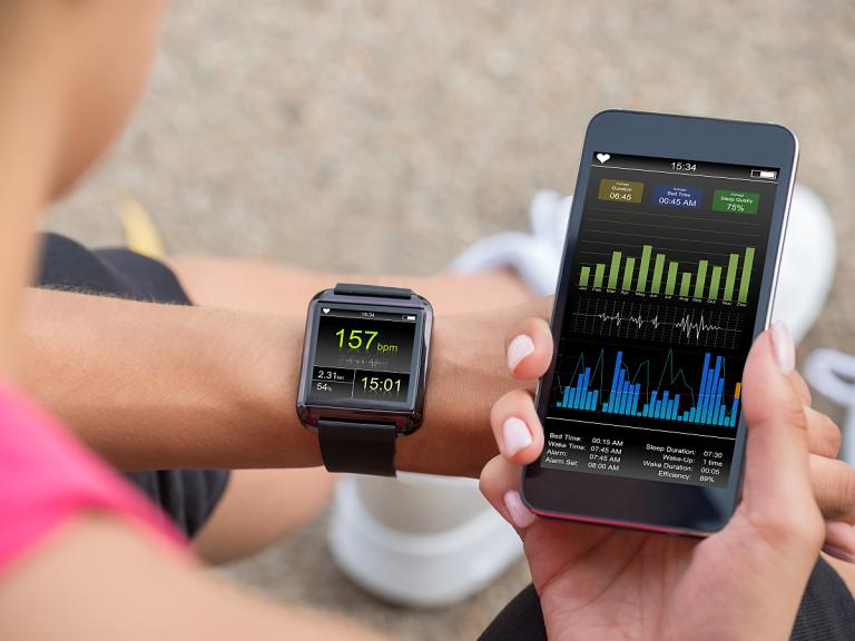 Female runner looking at her heart rate on the phone