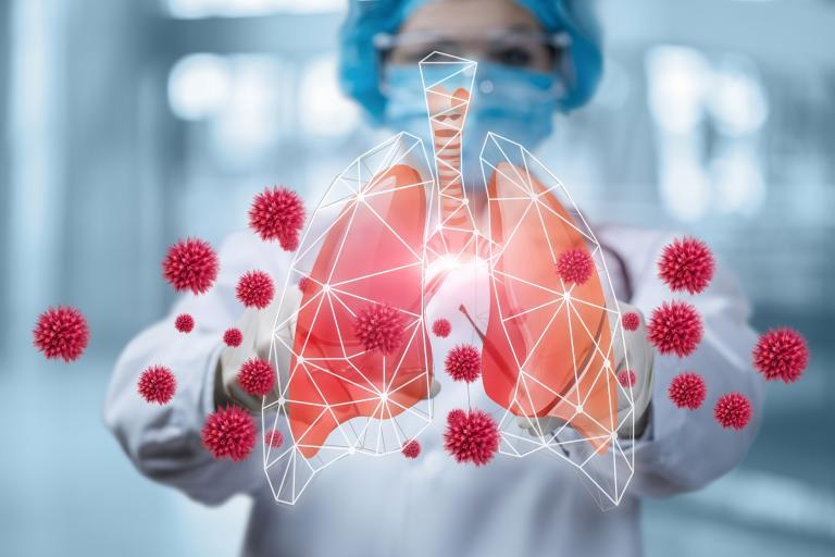 Clinician looking at animated lungs with coronavirus molecules