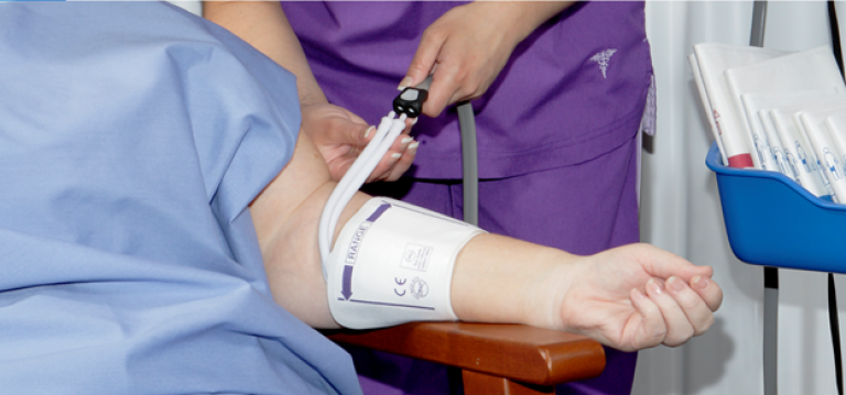 Clinician setting a NIBP cuff to a patient
