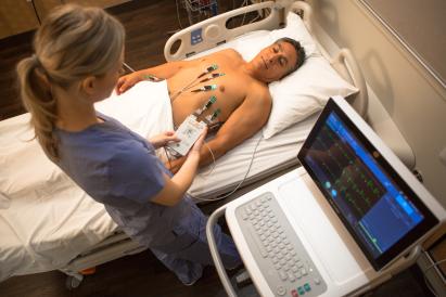 Patient lying on bed with ECG electrodes