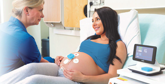 Pregnant woman wearing Novii wireless patch system fetal monitor