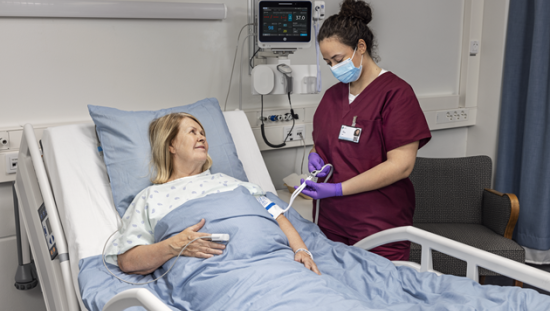 Clinician measuring BP to a female ICU patient