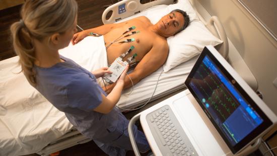 Patient lying on bed with ECG electrodes