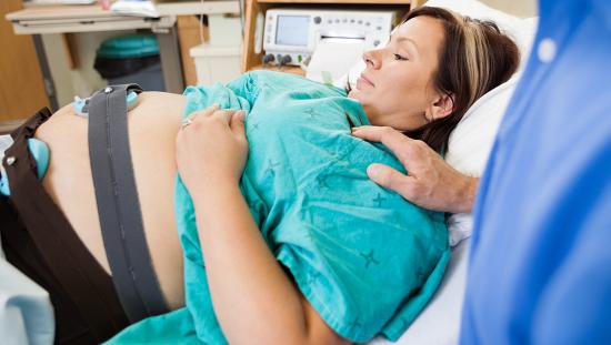 Pregnant women looking at her belly