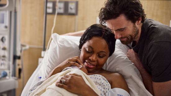 Mother and father with newborn baby in hospital