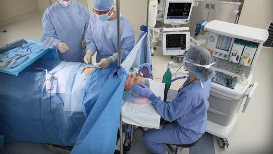 Three clinicians taking care of a patient in the OR