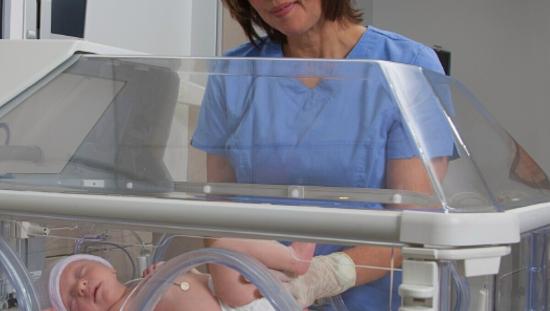 Baby in incubator with temperature probe