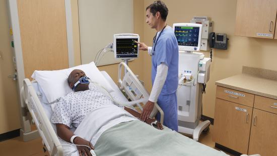 Clinician checking on a patient on a spirometer