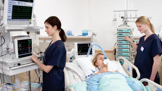 Clinicians taking care of a woman in the ICU