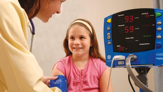 Doctor using the V100 monitor on a pediatric patient