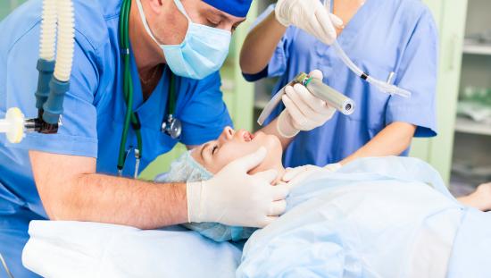 Anesthesiologist intubating patient